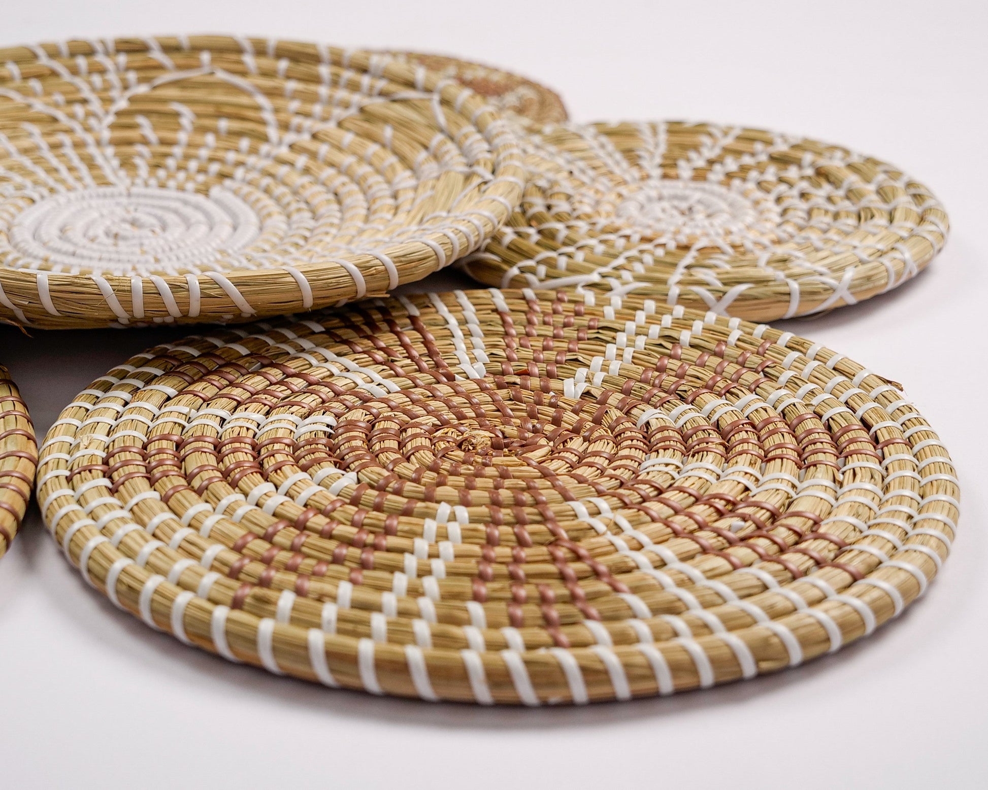 Handcrafted seagrass wall décor with natural and white patterns for boho interiors.